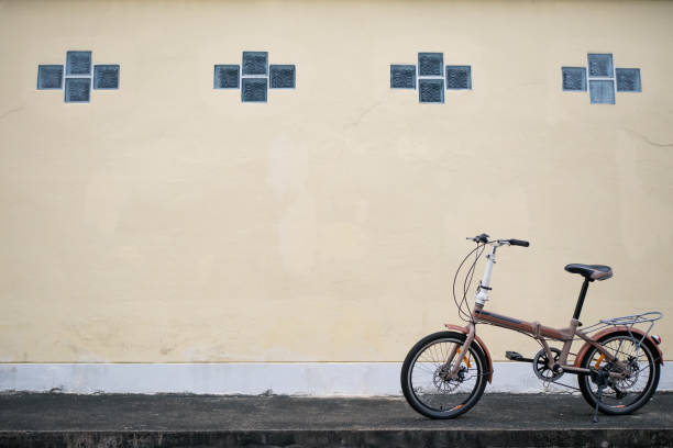istock Folding bike parked in front of yellow wall 1156783638