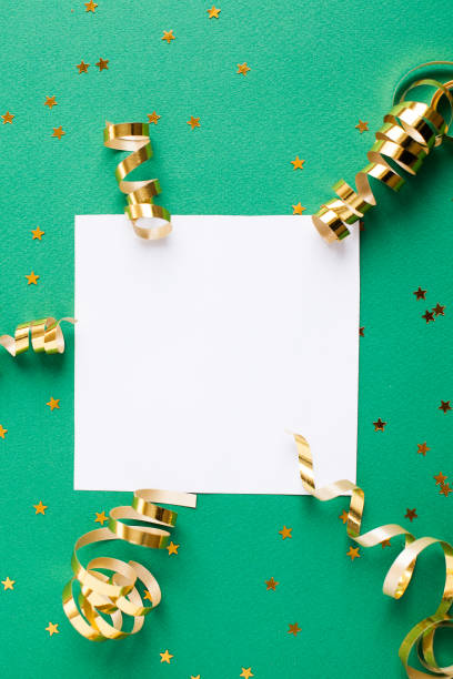 istock White paper sheet, golden decorations and sparkles on green background 1156786286