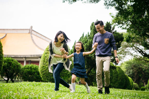 istock Smiling family holding hands on walk in park 1156786974