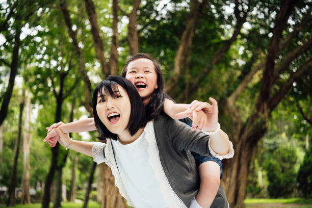 istock Cheerful mother giving daughter piggyback 1156786979