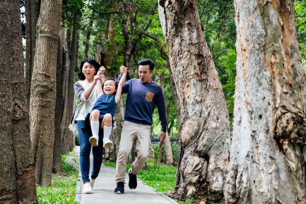 istock Parents swinging happy daughter in park 1156786984