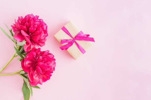 istock Flat lay composition with red peonies and gift box on a pink background 1156789717