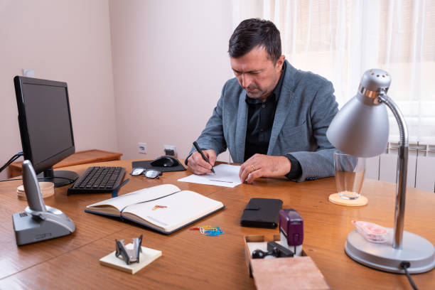 istock A man in a suit fills a questionnaire paper 1156790180