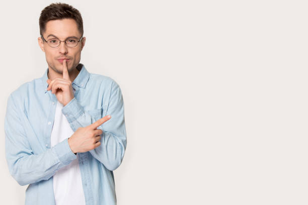 istock Man in glasses isolated on background shared secret point aside 1156795146
