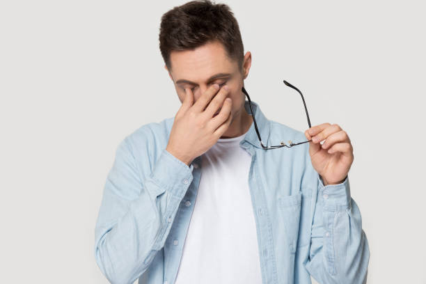 istock Stressed man take off glasses massaging eyes suffering from headache 1156795154