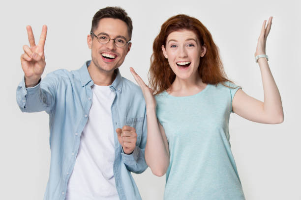 istock Smiling couple gesturing have fun posing for picture in studio 1156795186