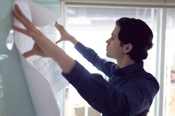 istock Male architect looking at blueprint in office 1156795613