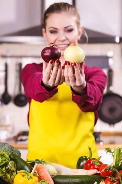 istock Woman holding red and white onion 1156796296