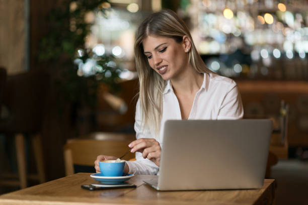 istock Businesswoman drinking coffee in a cafe while working on laptop 1156797831