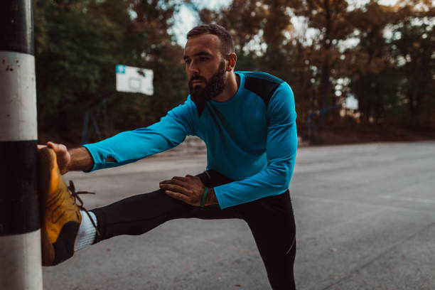 istock Handsome man stretching and exercising outdoors 1156797889
