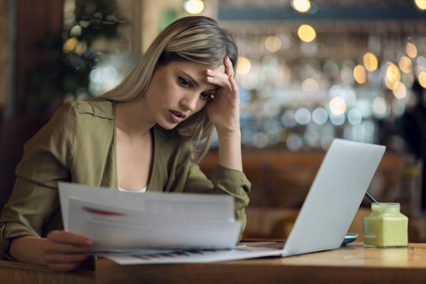 istock Worried businesswoman working on reports in a cafe 1156798297