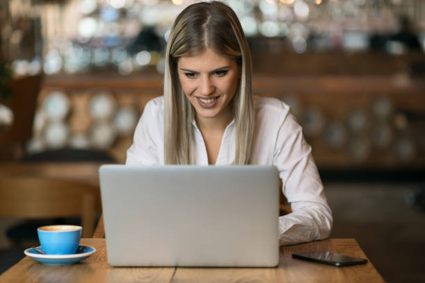 istock Young  woman using laptop and surfing the Internet in a cafe 1156799186