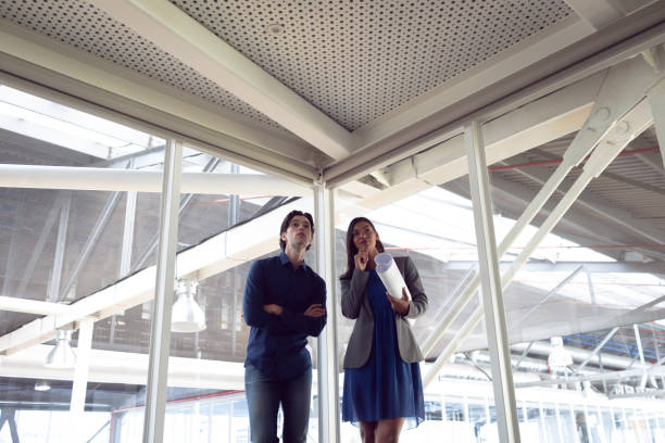 istock Male and female architects interacting with each other in office 1156799464