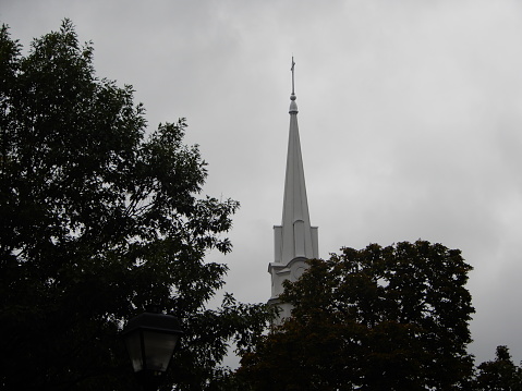 White church steeple rising into grey sky