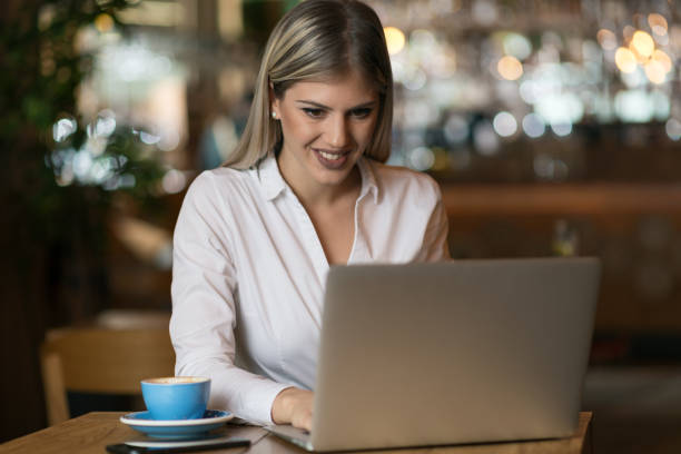 istock Young  woman using laptop and surfing the Internet in a cafe 1156801518
