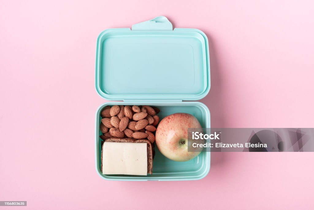 Lunch box with apple, sandwich and almond on pink background Back to school concept with copy space for text Lunch box with apple, sandwich and almond on pink background Back to school concept with copy space for text Top view Lunch Box Stock Photo