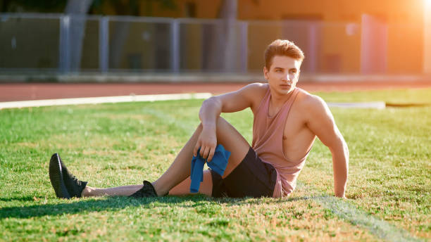 istock Young muscular man exercising with resistance stretch band on the stadium 1156809744