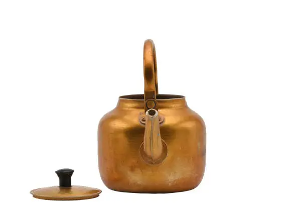 Photo of Golden metal kettle on a white background.Teapot.