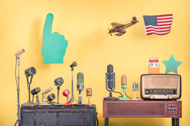 micros rétro, avion de jouet en bois de vol avec le drapeau des etats-unis, grand doigt pointant, vieille radio des années 50, 4 juillet sur le calendrier de bureau et fond jaune avant d'étoile d'honneur. photo filtrée de modèle de cru - fourth of july audio photos et images de collection