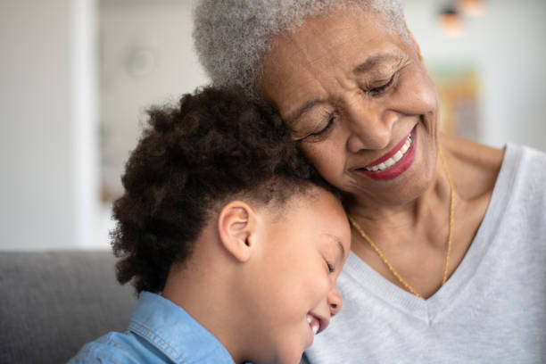 beautiful ethnic grandma is laughing with her young granddaughter. - great grandmother imagens e fotografias de stock