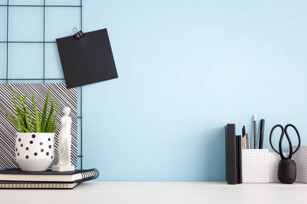 istock Office creative desk with supplies, figurine and blue wall. Mock up 1156822758