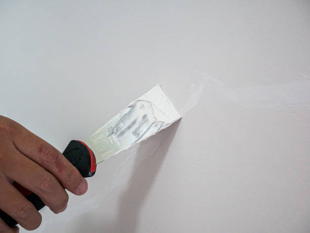 istock Plasterer hand repair crack white wall 1156822920
