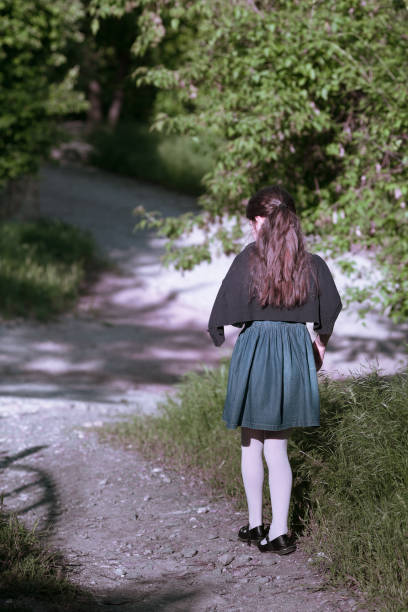 Little girl walking go away home on path. She dreams and sad.