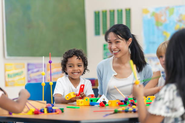 istock Young Asian Teacher Helps Her Male Student 1156823623