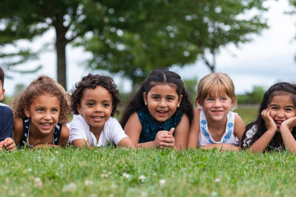 istock Multi-Ethnic Group of Kindergarten Kids Lying in the Grass 1156823658