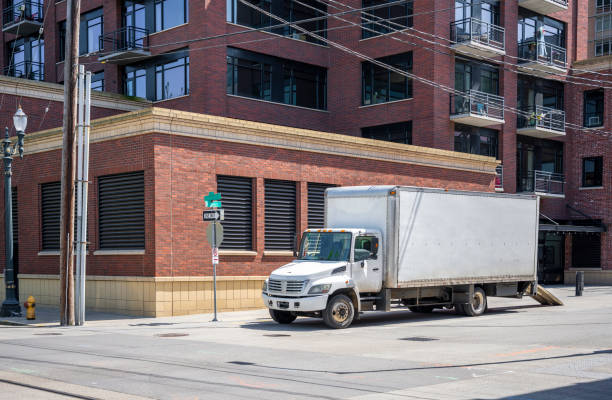 istock Compact small rid semi truck with box trailer standing in down town for loading moving goods 1156827159
