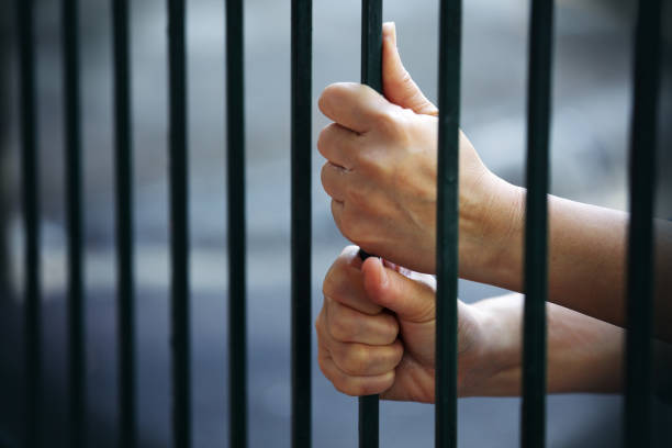 istock close up of hand in jail background 1156827832