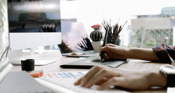 istock Attractive female graphic designer working at her desk in modern office 1156829449