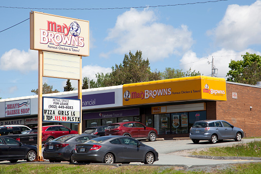 Sackville, Nova Scotia, Canada- June 15, 2019: A Mary Browns Fried Chicken eatery with Pizza Girls and other businesses in the strip