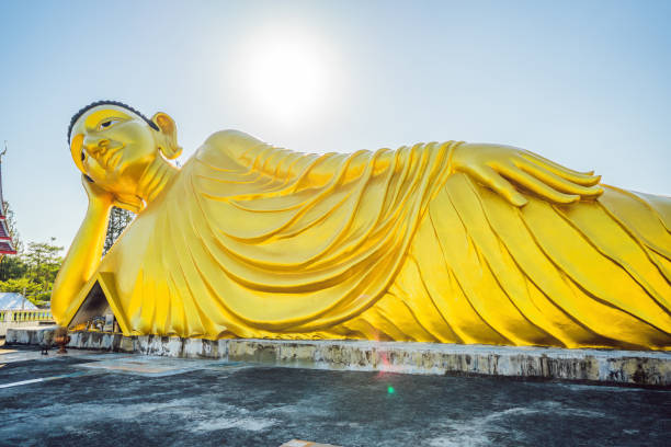 estatua de buda mentiroso hecha con fondo de cielo azul - wat pho fotografías e imágenes de stock