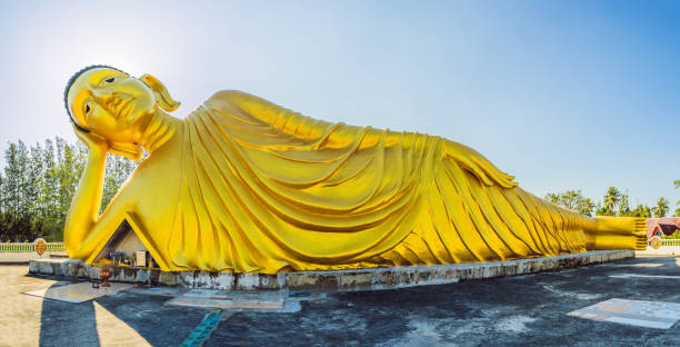 estatua de buda mentiroso hecha con fondo de cielo azul - reclining buddha fotografías e imágenes de stock