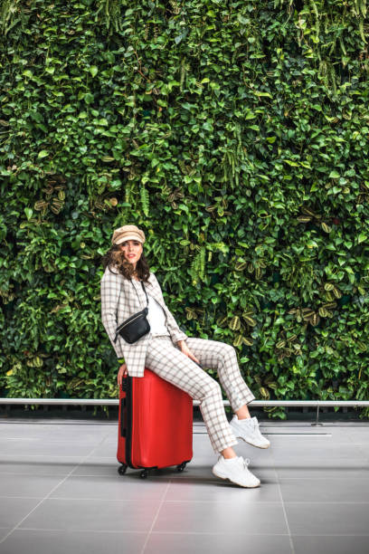 녹색 벽에 대한 공항에서 젊은 아름다운 여자입니다. - business travel luxury indoors plant 뉴스 사진 이미지