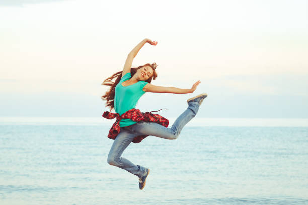 istock girl jumping by the sea 1156840931