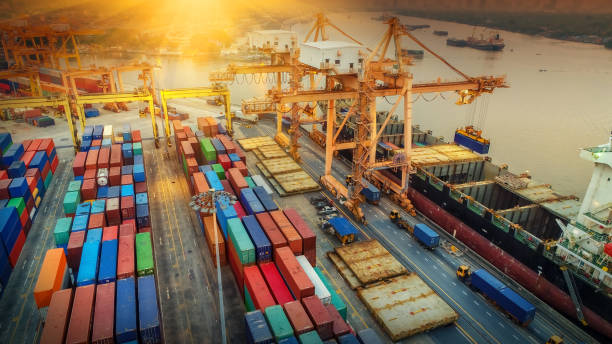 istock Logistics and transportation of Container Cargo ship and Cargo plane with working crane bridge in shipyard at sunset, logistic import export and transport industry background 1156844339