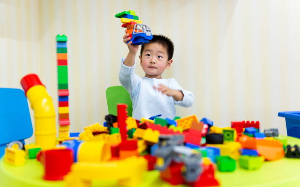 Little boy playing with colorful toy block.