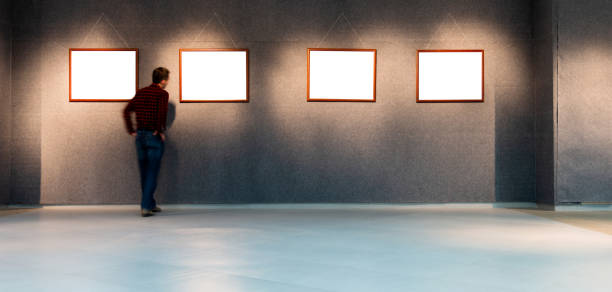 istock Man looking at white frames in an art gallery 1156845137