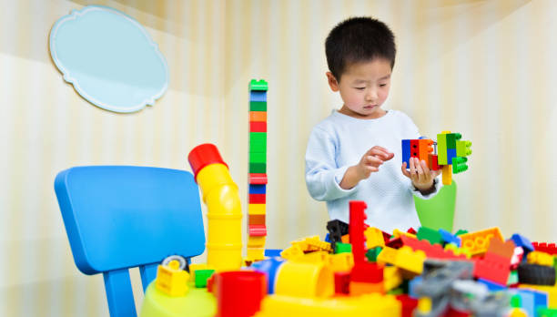 istock Little boy playing with colorful toy block 1156845140