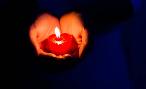 istock Woman hands holding candle light 1156845194