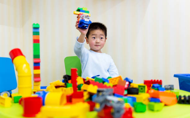 Little boy playing with colorful toy block.
