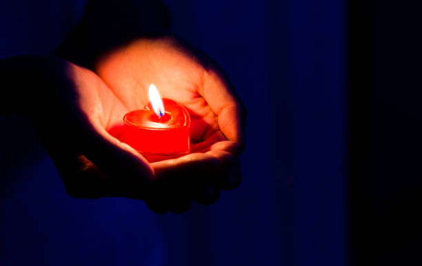 istock Woman hands holding candle light 1156845244
