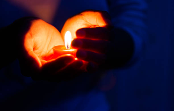 istock Woman hands holding candle light 1156845276
