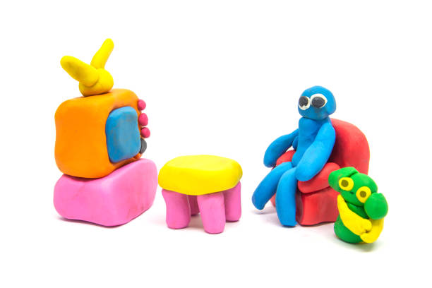 istock Play dough man sitting on red sofa on white background 1156847890