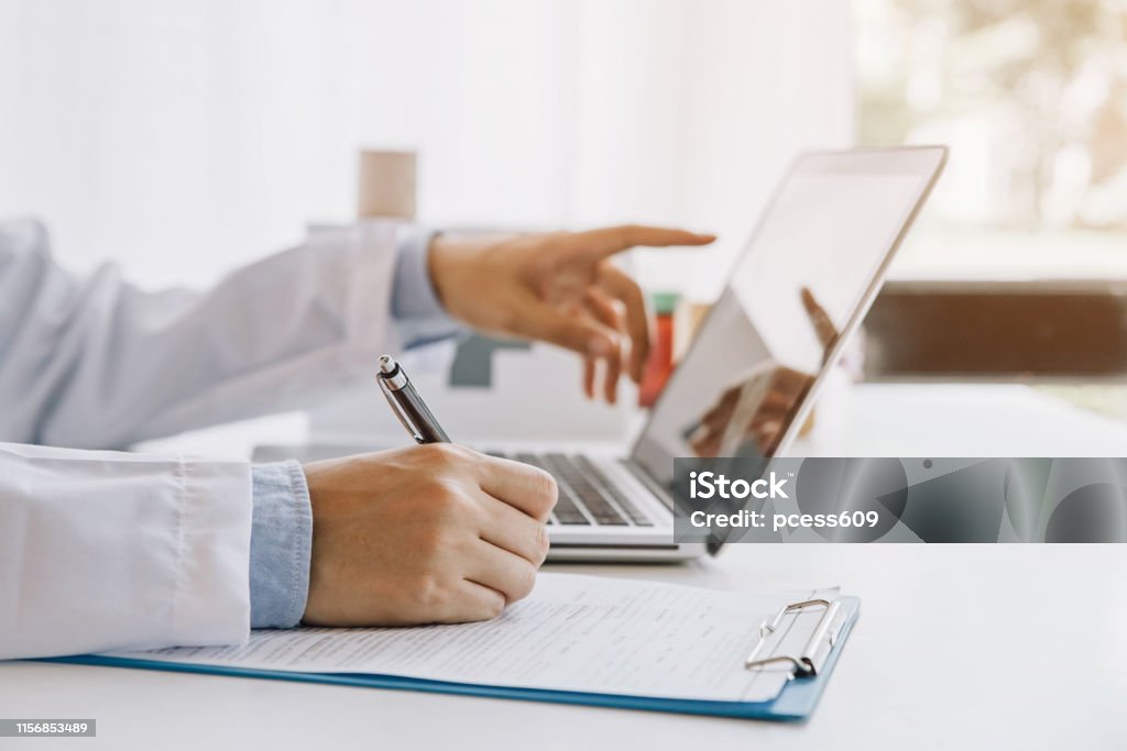 Arzt im Krankenhaus schreiben medizinische Dokumentation und mit Laptop - Lizenzfrei Arzt Stock-Foto