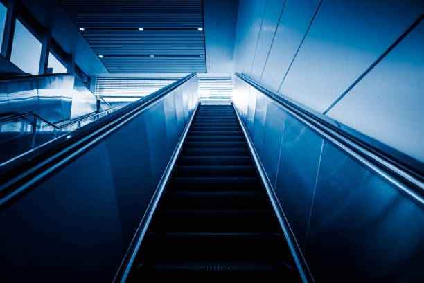 istock Low angle view of escalator,blue toned 1156857303