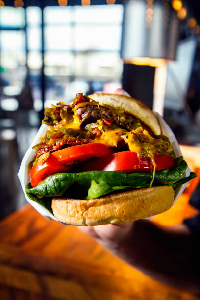 istock Person holding a big burger 1156859187