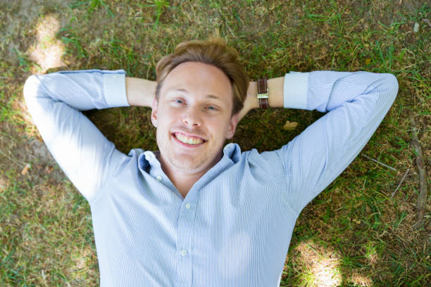 istock Cheerful happy guy posing on grass in park 1156862945